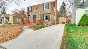 A two-story house with a front porch, a driveway, and a well-maintained lawn. - Walk to Adrian College: Family Home in Michigan (Adrian)
