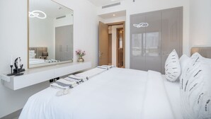 Ein modernes Schlafzimmer mit einem großen Bett, einem Nachttisch, einem Spiegel und einem Kleiderschrank.