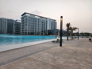 Relax by the pool surrounded by lounge chairs and umbrellas.