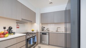 Una cocina moderna con electrodomésticos de acero inoxidable, armarios de madera y lavavajillas integrado.