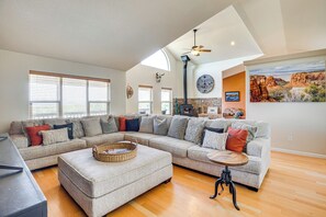 A spacious living room with a sectional sofa, a wooden coffee table, and a fireplace. - Luxe Mesa View Home on 35 Acres w/ Wraparound Deck (Glade Park)