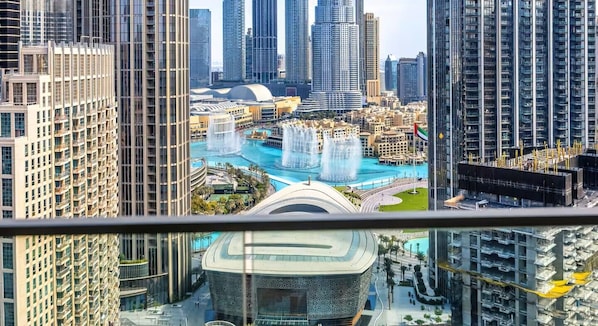 A high-rise building with a view of a water park and a distinctive building with a circular design.