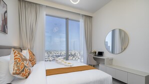 Ett modernt hotellrum med en stor säng, ett skrivbord och utsikt över staden.