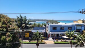 A coastal town with a view of the sea, featuring a 'Husky Living' hotel, 'Harley's' restaurant, and a beachfront café. - Holiday In Husky by Book Jervis Bay - 2 Bedroom Apartment located in the centre of town (Huskisson)