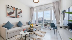 A modern living room with a sofa, coffee table, and chairs. There are abstract paintings on the wall, a large window with curtains, and a balcony with a view of the city. - Vogue, Al Wasl Residences Dubai Frame view near World Trade Centre (Dubai)