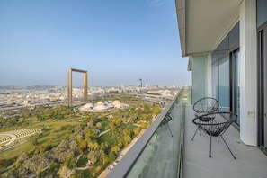 A balcony with a view of a cityscape, including a large arch structure and domed buildings.