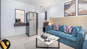 Ein modernes Wohnzimmer mit einem blauen Sofa, einem Couchtisch und einem Kühlschrank.