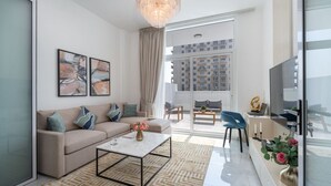 A modern living room with a sofa, coffee table, and artwork on the wall. - Vogue, Al Furjan Pearlz by Danube near Ibn Battuta Mall (Dubai)