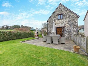 Une maison en pierre dotée d’une terrasse, d’un espace salon extérieur et offrant une vue sur la campagne environnante.
