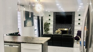 Una cocina moderna con una isla central, lavavajillas integrado y salpicadero blanco y negro.