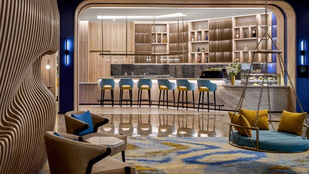 Ein modernes Interieur mit Bar, Sitzgelegenheiten mit Kissen und einer Hängeschaukel.