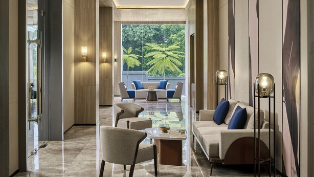A modern living room with a glass coffee table, sofas, and floor lamps. - voco Bandung Setiabudi by IHG (Bandung)