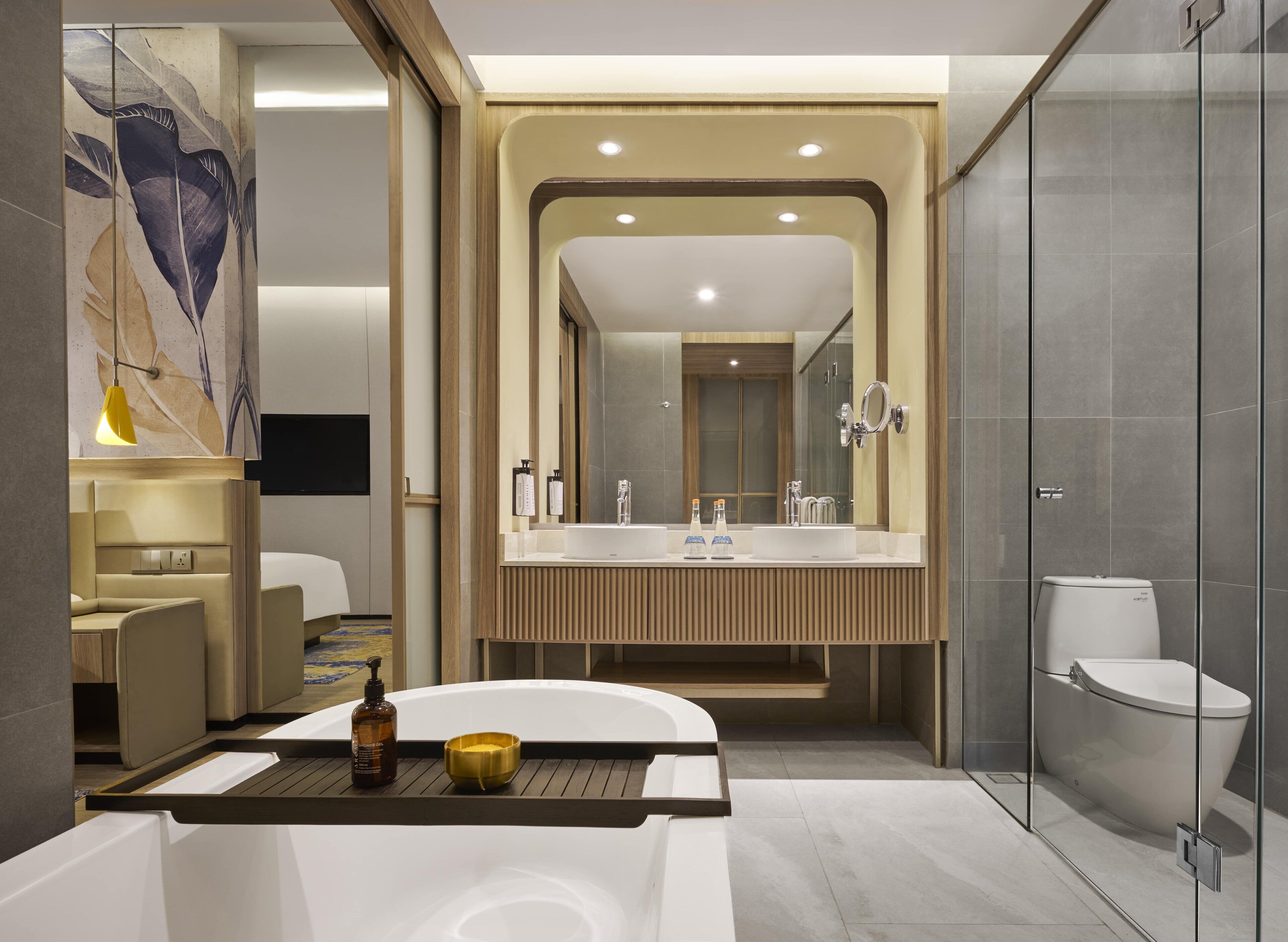 A modern bathroom with a large mirror, dual sinks, a bathtub, and a shower.