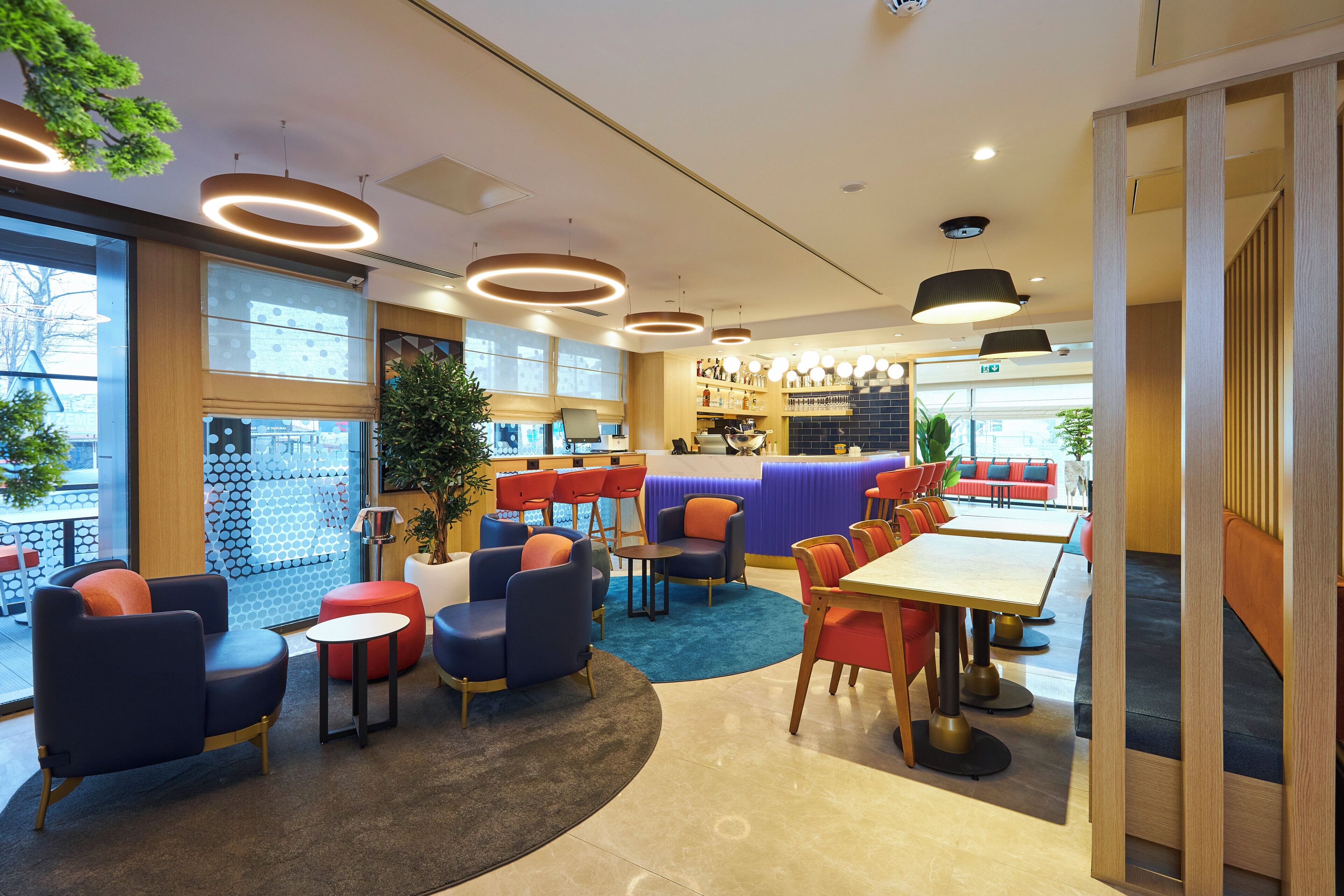 A modern interior with seating areas, a counter, and a view through large windows.