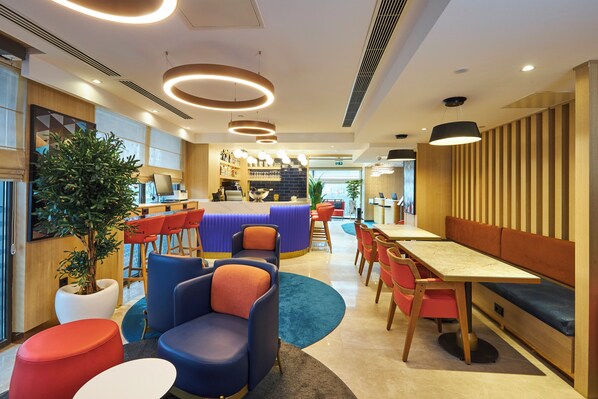 A modern interior with a bar area, seating, and a potted plant. - Holiday Inn Express Istanbul - Airport Arnavutkoy by IHG (Arnavutkoy)