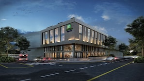 Un edificio moderno con un letrero de Holiday Inn Express, ventanas grandes y un estacionamiento con automóviles.