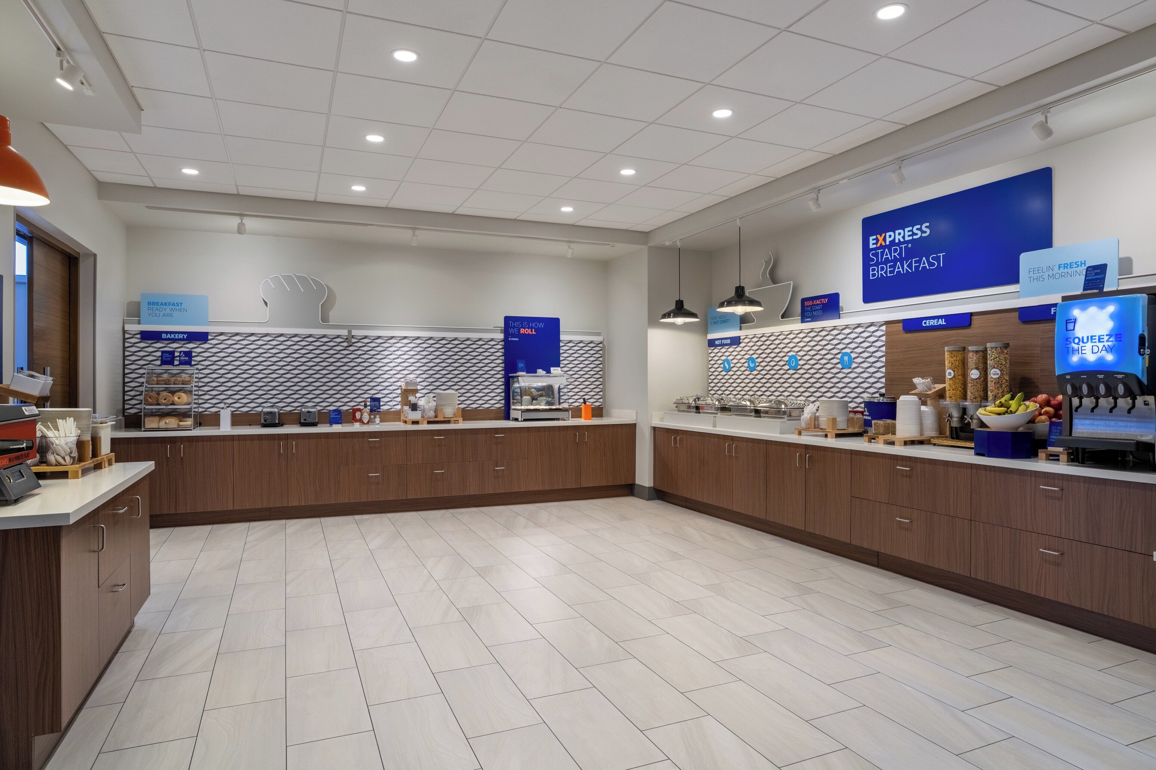 Un grand espace dédié au petit-déjeuner, comprenant un coin boulangerie, un présentoir de céréales et un saladier rempli de fruits.
