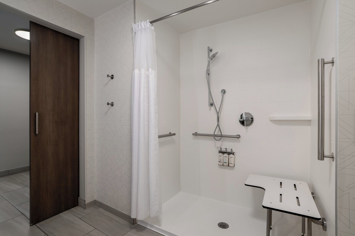 A modern bathroom with a shower, a toilet, and a sink.