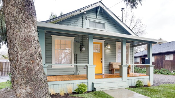 A single-story house with a porch, a front door, and a small front yard. - Walkable Location: Quaint Cottage in Forest Grove! (Forest Grove)