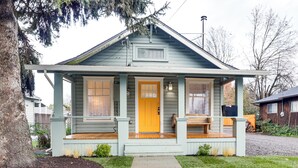 A house with a porch, a front door, and a small window. - Walkable Location: Quaint Cottage in Forest Grove! (Forest Grove)
