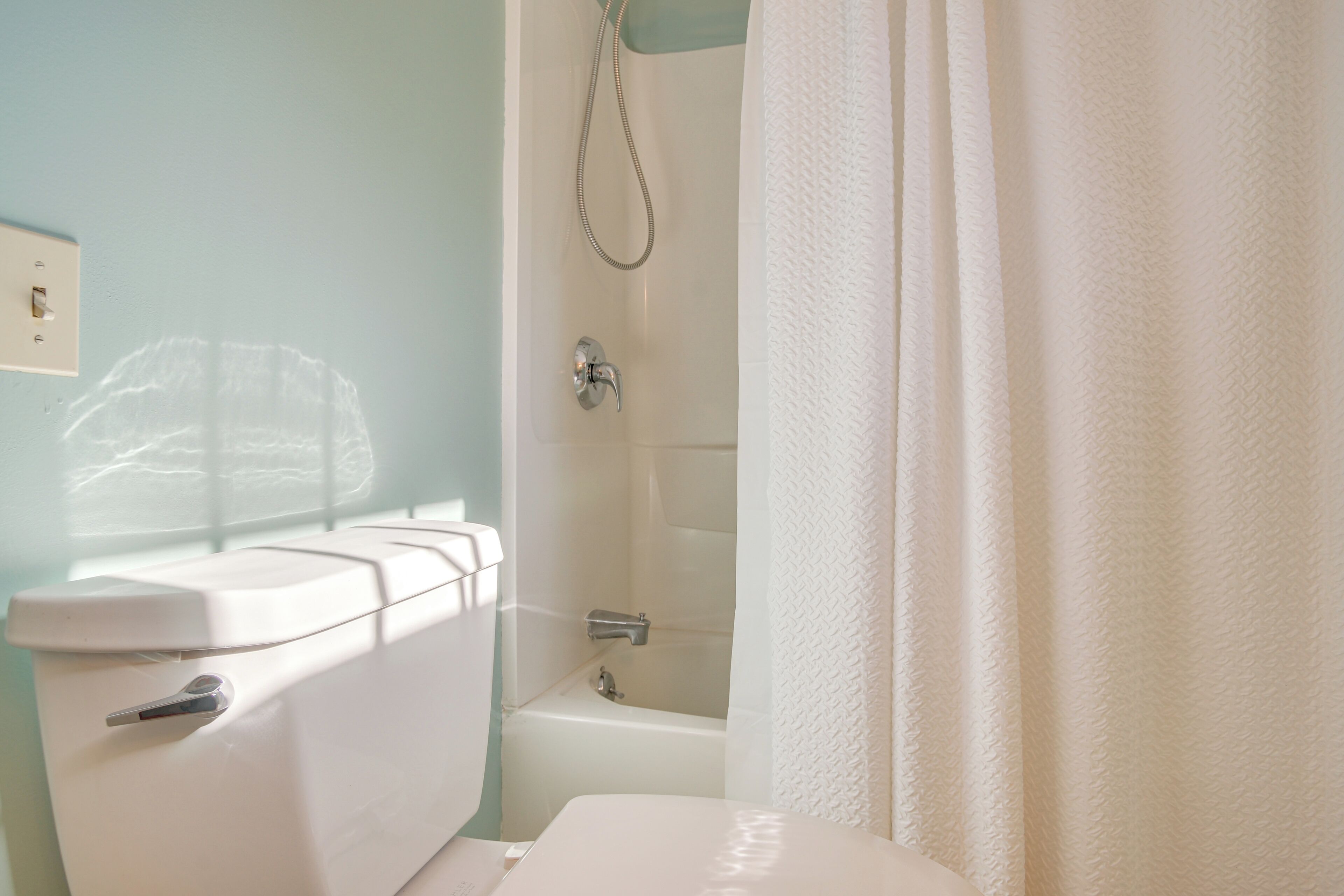 Ein Badezimmer mit Toilette, Badewanne und Duschvorhang.