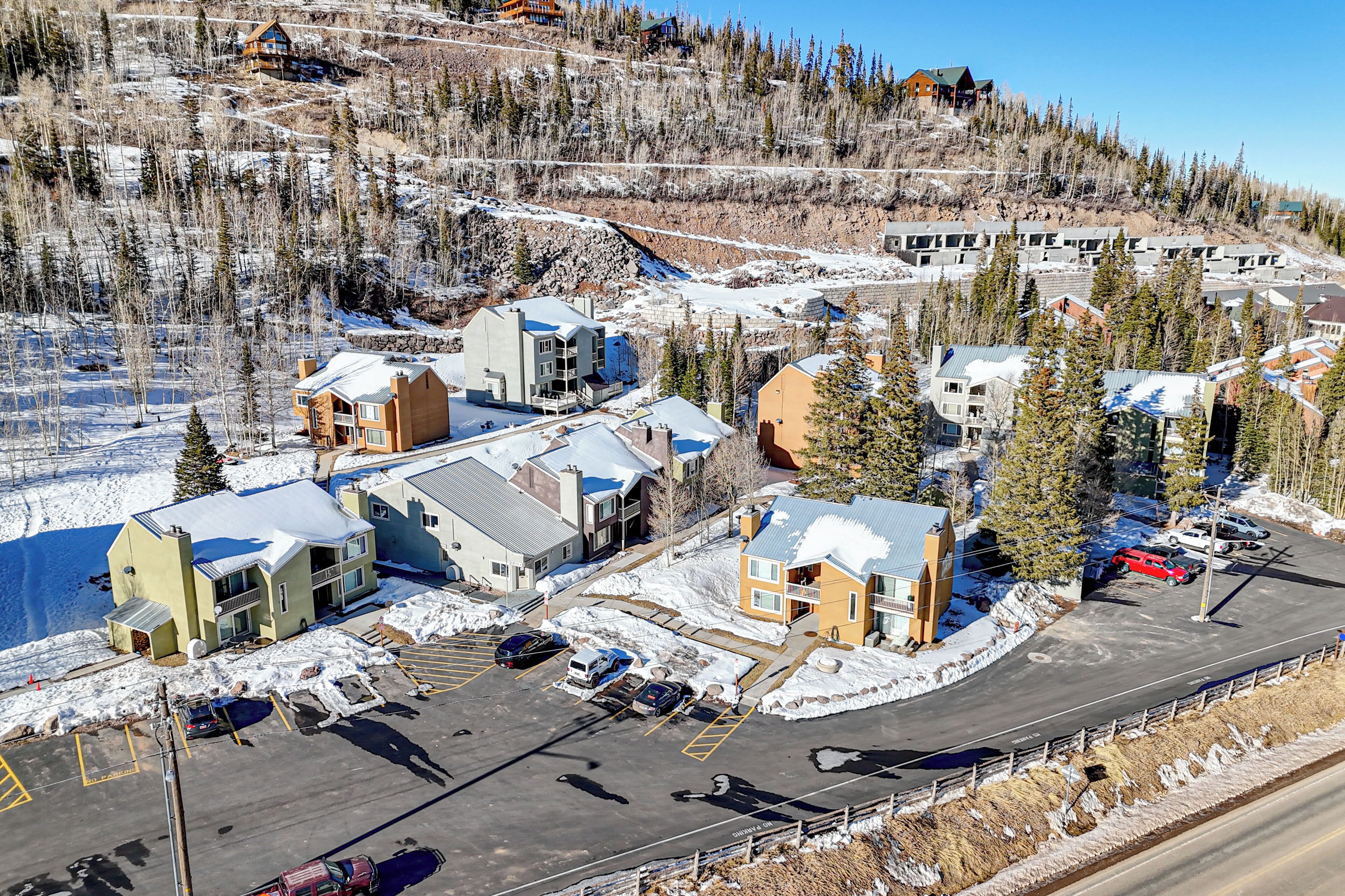 A ski resort with multiple buildings, parking areas, and snow-covered terrain.