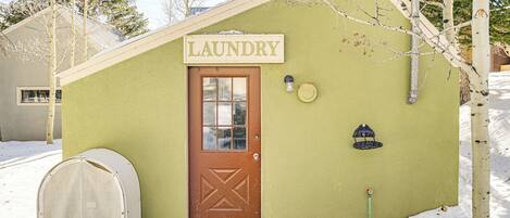 A small laundry facility with a brown door and a sign that reads "LAUNDRY".
