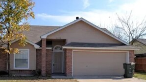 A single-story house with a garage, a front door, and a small front yard.