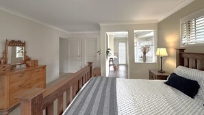 Ein Schlafzimmer mit einem Bett, einem Holzschrank und einem Nachttisch mit einer Lampe.
