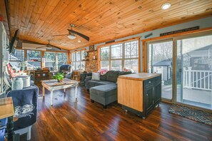 A spacious living room with a wooden ceiling, large windows, a fireplace, and a cozy seating area. - Large Family Home: 5 Mi to Dtwn Hagerstown! (Williamsport)