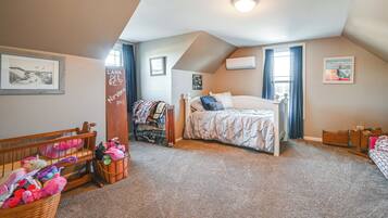 A cozy bedroom with a bed, a crib, and a dresser.