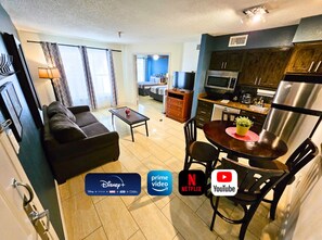 A modern hotel room with a living area, kitchenette, and a balcony. - Pool View  Family Condo Disney Universal Orlando (Kissimme)