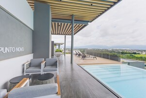 Una piscina al aire libre, sillones reclinables de piscina