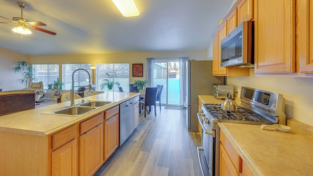 A kitchen with wooden cabinets, a stainless steel stove, and a microwave. - ~ 3 Mi to Ski & Hiking Trails: Soldotna Home (Soldotna)
