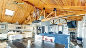 Een ruime keuken met moderne apparatuur, een eethoek met een houten tafel, en een gezellige zithoek met een open haard.