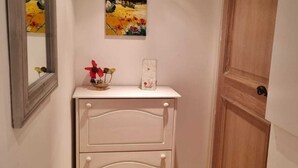 Passadís amb un aparador blanc, un quadre a la part superior i una porta de fusta.