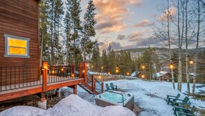 A wooden cabin with a hot tub, outdoor seating, and a deck overlooking a snowy landscape. - Mtn & Lake Views, Hot Tub, Dog Friendly, Chef's Kitchen, 5 min to Main St Breck (Breckenridge)