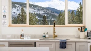 A kitchen with a large window overlooking a snowy mountain landscape. - Mtn & Lake Views, Hot Tub, Dog Friendly, Chef's Kitchen, 5 min to Main St Breck (Breckenridge)