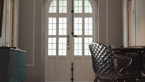 Una habitación amplia con un gran arco, suelo con diseño y una silla moderna.