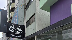 Un hostal con letrero, asientos exteriores y vista a la calle.