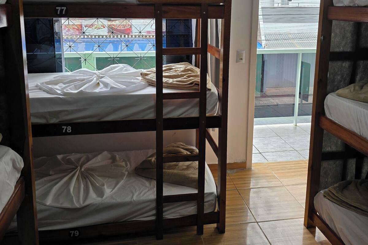 A dormitory room with bunk beds numbered 77, 78, and 79.