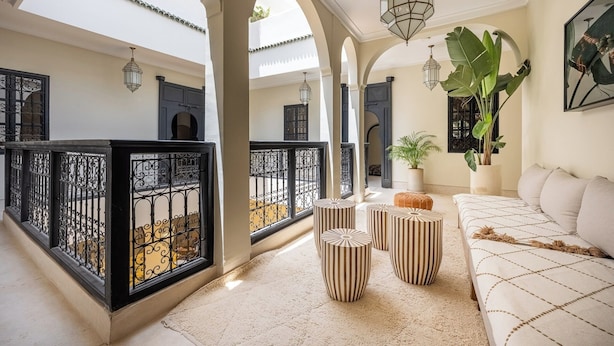 A spacious interior with high ceilings, arched doorways, and a seating area with a sofa and ottomans. - Riad Nayl, Luxury and Comfort 5 minutes from Jamaa El Fna (Marrakesh)