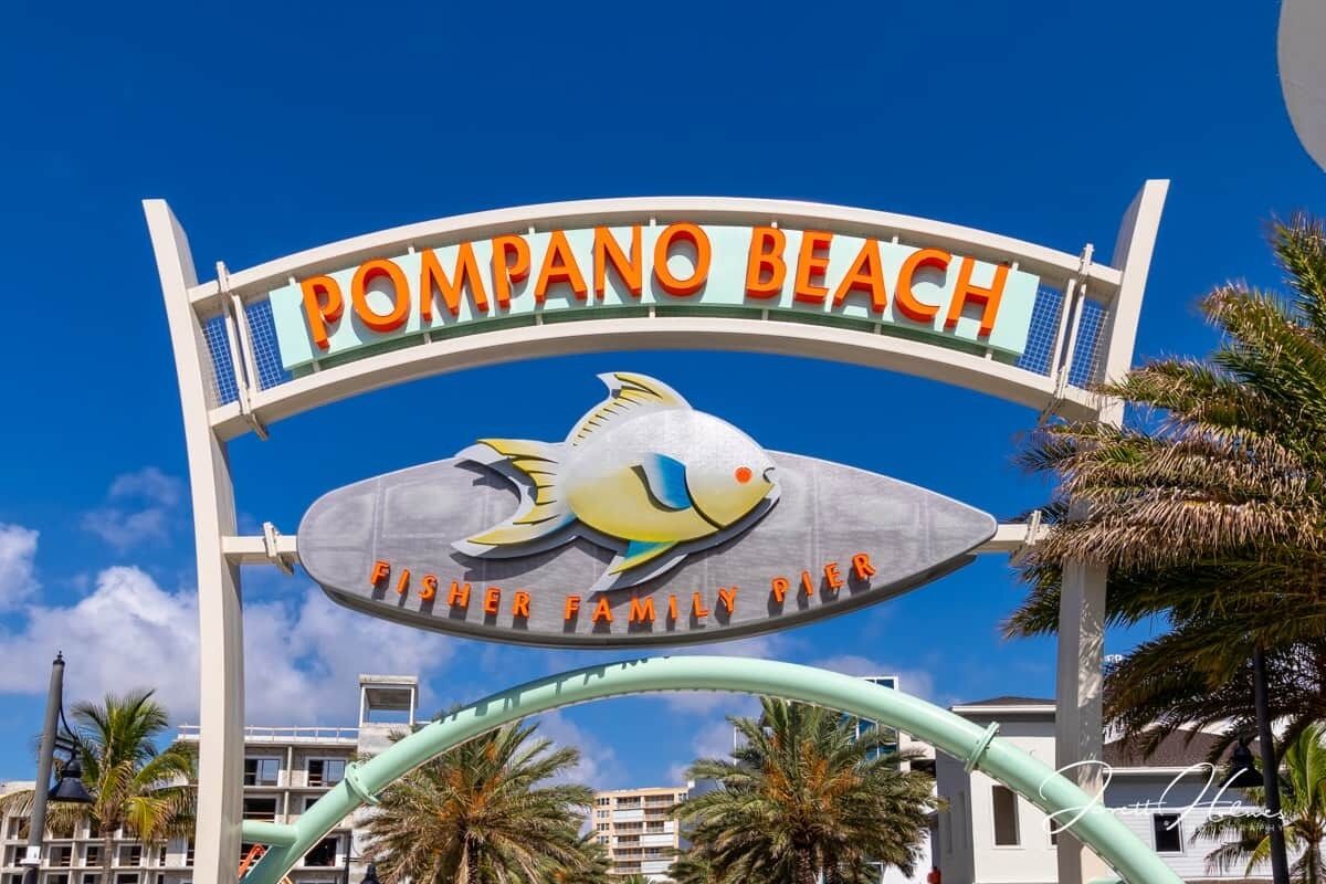 Ein Schild für den Pompano Beach Fisher Family Pier mit stilisierter Fisch-Logos.