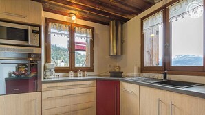 Une cuisine avec des armoires en bois, un four à micro-ondes, une cuisinière et un évier.