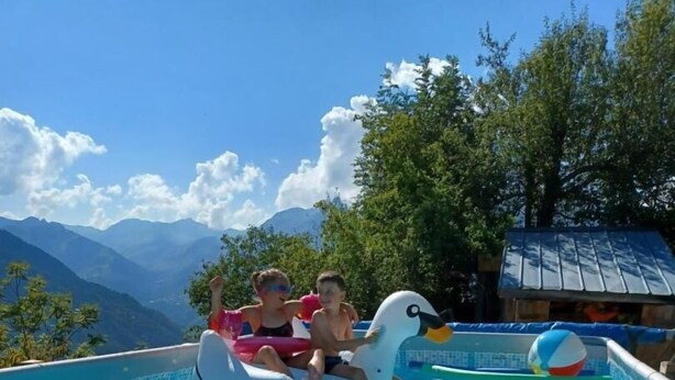 Une piscine avec un flotteur en forme de cygne et un ballon de plage.