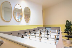 Relax and unwind in this stylish room, featuring a foosball table and a calming atmosphere.