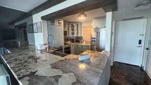 A modern kitchen with granite countertops, stainless steel appliances, and a built-in oven.