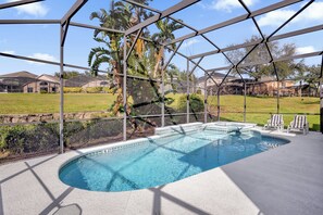 A swimming pool with a glass enclosure, surrounded by a patio area with lounge chairs. - Pool, Themed Rooms, Resort (Kissimmee)