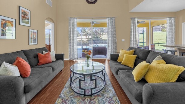 A spacious living room with two grey sofas, a glass coffee table, and a patterned rug. - Pool, Themed Rooms, Resort (Kissimmee)