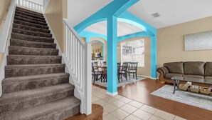 A staircase with carpeted steps, a wooden handrail, and a white railing. - Pool, Themed Rooms, Resort (Kissimmee)